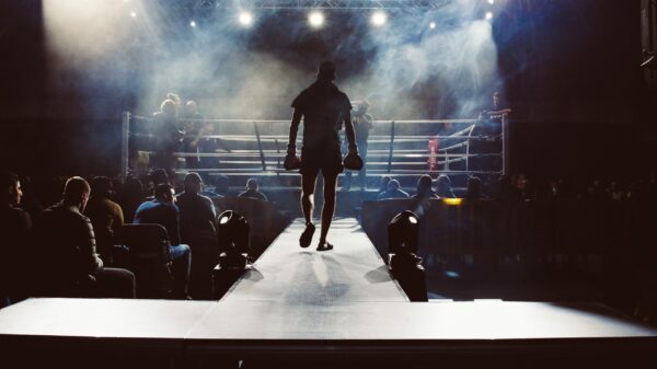 man standing and walking going on boxing ring surrounded with people