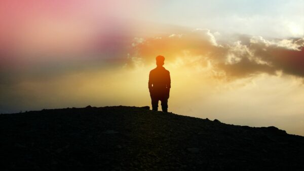 silhouette of person standing on hill