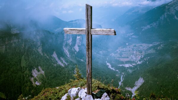 photo of brown wooden cross at cliff